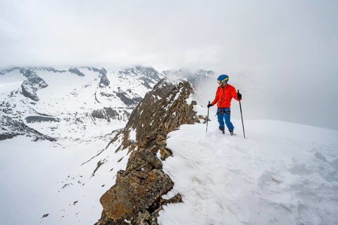 Ski tourers on rocky ridge with snow