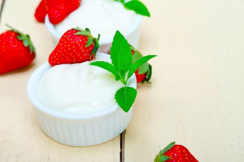 Organic Greek yogurt and strawberry over white rustic wood table