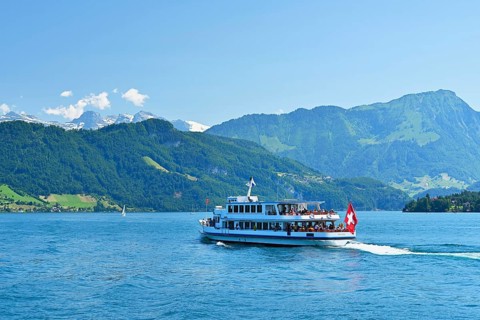 Motorboat Weggis cruises on Lake Lucerne in sunny weather.