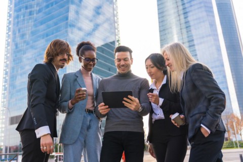 A group of multi-ethnic business people in a business park looking at a tablet