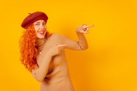 Red-haired woman in a red beret on a yellow background