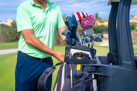 Man caucasian in the Buggy with the bag of clubs playing golf