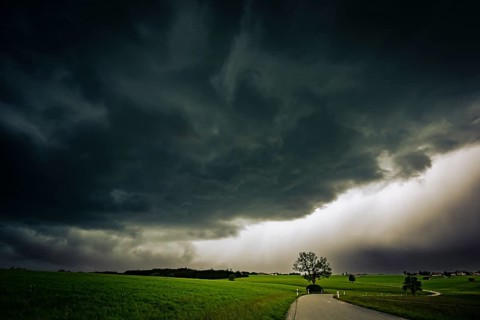 Road and meadows with thunderstorm sky in the background