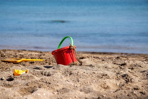 Sand toys on the beach with water surface in the background