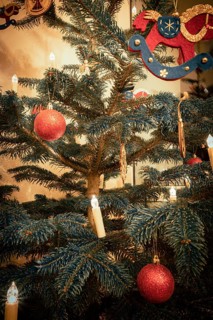 Red Christmas tree balls on a Christmas tree and a rocking horse made of felt with Christmas tree lights