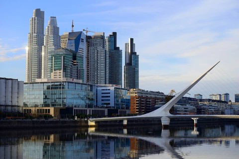 Skyscrapers and the Puente de la Mujer bridge reflected in the water