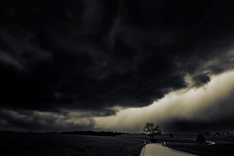 Road and meadows with thunderstorm sky in the background