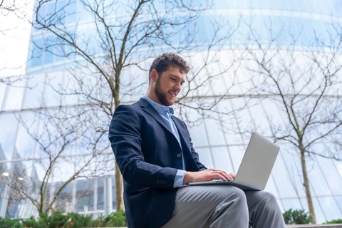 Young businessman or finance man looking at computer outside office