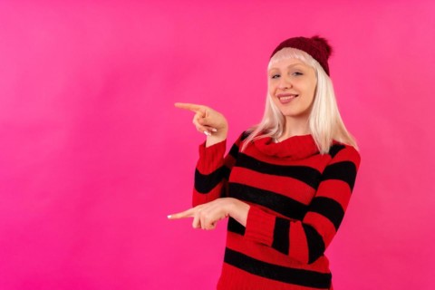 Blonde caucasian girl on pink studio background