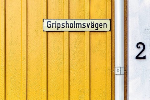 Street sign on a yellow painted wooden house