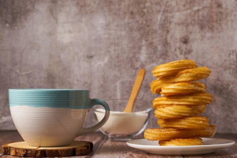 Hot chocolate with churros in a white and blue cup