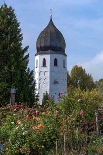 Bell tower with flower garden of the Frauenwoerth monastery church and abbey