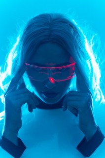 Portrait of a woman in a futuristic suit and glasses with blue led lights