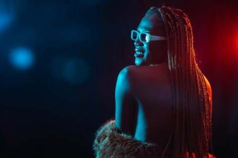 Black ethnic woman with braids with blue and red led lights