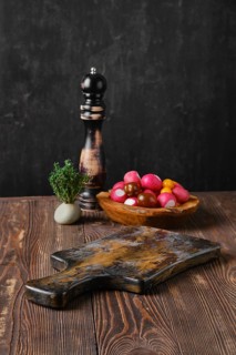 Rustic kitchen table with fresh vegetables and pepper mill blurred on background