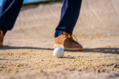 Detail of the feet of a man playing golf