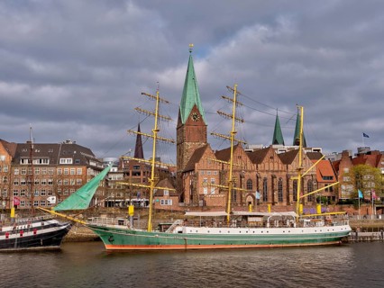 Sailing ship "Alexander von Humboldt" on the banks of the Weser with the red brick buildings of the old town in the background