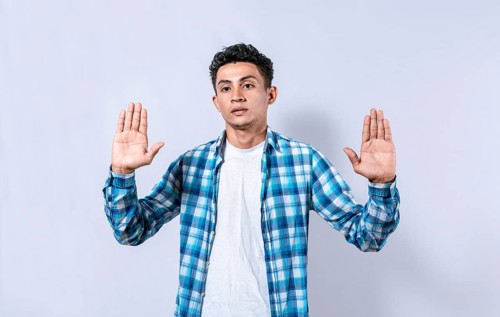Scared and horrified man with raised palms