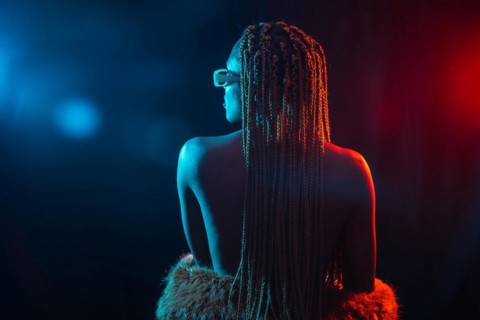 Woman of black ethnicity with braids with blue and red led lights