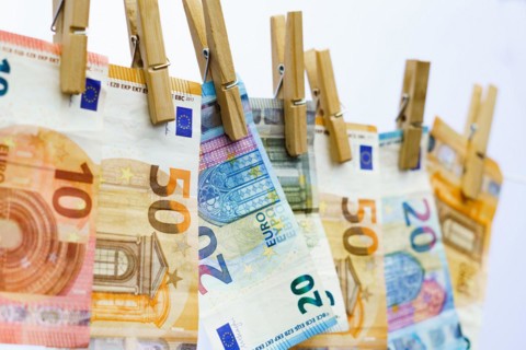 Euro banknotes hung on a clothesline with clothespins white background for copy space