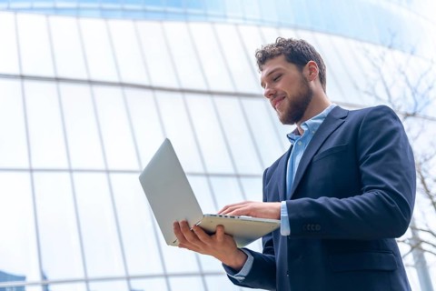 Young businessman or finance man looking at computer outside office
