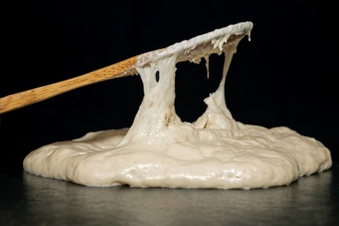 Bamboo spoon and baking dough with yeast