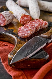 Fermented air-dried salami on wooden cutting board cut on slices