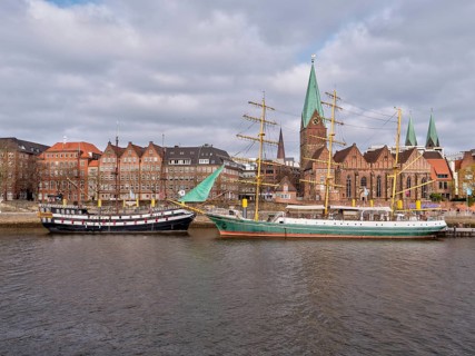 A faithful replica of the frigate "Picton Sea Eagle" and the sailing ship "Alexander von Humboldt" on the banks of the Weser with the red brick buildings of the old town in the background