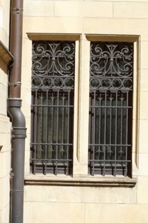 Window with ornate window grille on a house wall