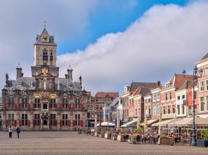 The beautiful Restored Town Hall Stadhuis Delft next to the traditional buildings on the Market Square