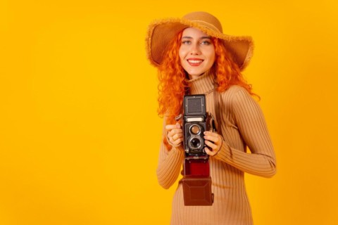 Red-haired woman tourist on a yellow background