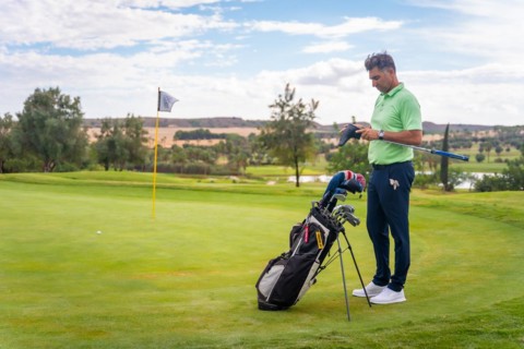 Caucasian professional golf player on the green preparing for the shot