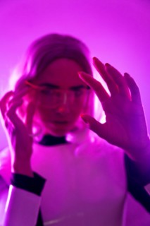 A woman in a suit and futuristic glasses with pink lights