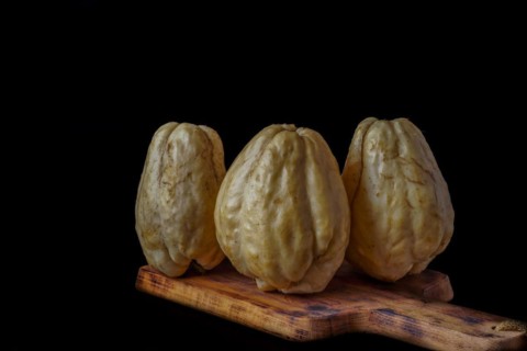 Chayotes isolated on a black background on a wooden board