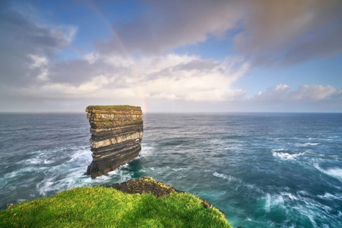 Downpatrick Head with gigantic rock with stormy Atlantic with rainbow