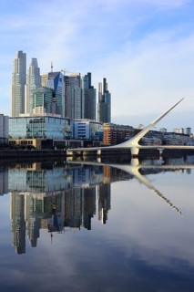 Skyscrapers and the Puente de la Mujer bridge reflected in the water