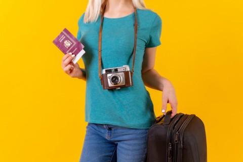 Unrecognizable person tourist with suitcase and passport