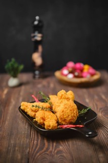 Selective focus photo of deep fried breaded chicken wings on shabby serving board