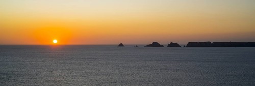 Sea cliffs at the Pointe de Pen-Hir and Les Tas de Pois sea stacks silhouetted against sunset on the Crozon Peninsula
