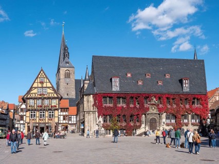 On the right historic town hall in red autumn leaves