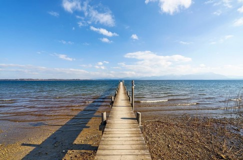 Footbridge on the lake under a blue sky