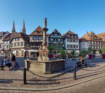 Sainte-Odile fountain on the Pl. Beffroi square and half-timbered houses in the background