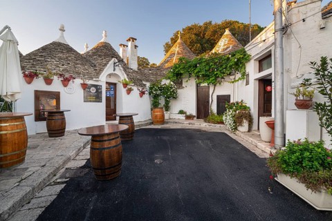 Wine barrels in front of trulli with flowers