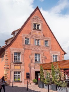 A red building with painted ornaments around the windows and doors in the district of La Petite Venise