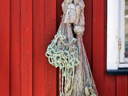 Net hanging from red wooden fishing hut