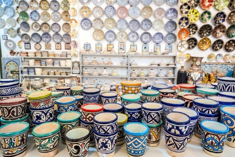 Shelves full of handmade ceramic products in pottery factory in Fez