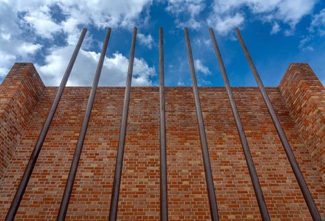 Rusty iron bars in front of brick wall