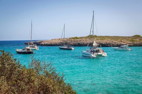 Sailing boats and catamaran in Cala Varques bay