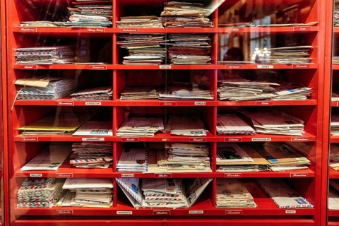 Red mailboxes with letters behind glass