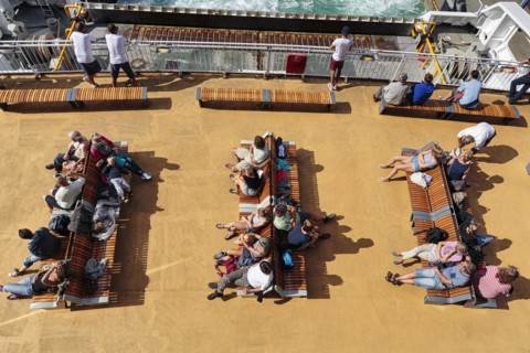Passengers sitting on benches on deck